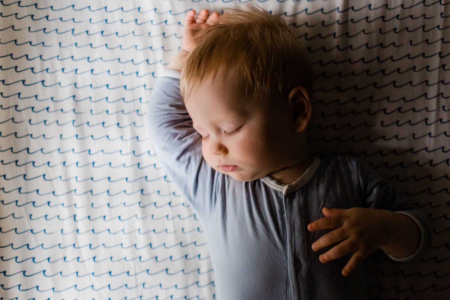 baby-boy-sleeps-in-crib-moody-light